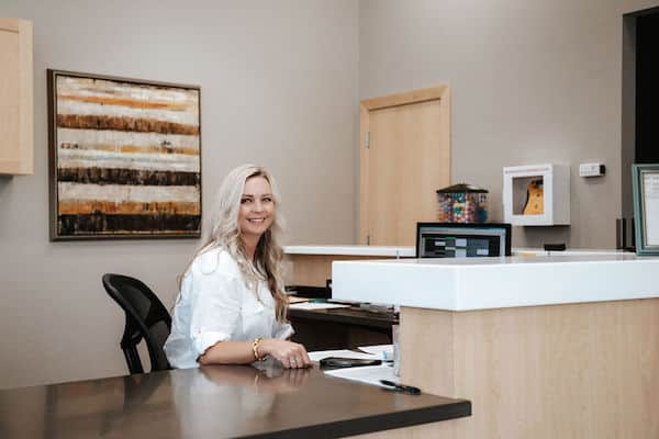 front desk lady smiling at genesis dental south jordan location