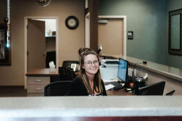 Utah Extended Hours Dentist in Utah front desk lady smiling at genesis dental south jordan location Genesis Dental and Orthodontics dentist near me, children's dentistry, pediatric dentistry, family dentisry, general dentistry, cosmetic dentistry, braces, metal braces, traditional braces, invisalign, clearcorrect, clear aligners, damon brackets, emergency dental dentistry, dental implant, implants, crown, crowns, cerec, filling, fillings, sealant, sealants, bond, bonding, frenectomy, gum recontouring, root planing, dentures, partial denture, full dentures, implant retained denture, cracked tooth, loose teeth, discolored tooth porcelain fillings, tooth-colored amalgam fillings, dental exam, xray, cleaning, cleanings, teeth whitening, zoom whitening, dentist open on saturday, dentist open on sunday, emergency dentist serving utah and kansas, serving SALT LAKE CITY, UT,TAYLORSVILLE, UT, SOUTH JORDAN, UT, OREM, UT, MAGNA, UT, WEST VALLEY CITY, UT, DISTRICT ORTHODONTICS UT, BRIGHT SMILES DENTAL UT, THANKSGIVING POINT, CENTRAL AVE DENTAL KS, OVERLAND PARK, KSgenesis dental taylorsville front office coordinator Genesis Dental and Orthodontics dentist near me, children's dentistry, pediatric dentistry, family dentisry, general dentistry, cosmetic dentistry, braces, metal braces, traditional braces, invisalign, clearcorrect, clear aligners, damon brackets, emergency dental dentistry, dental implant, implants, crown, crowns, cerec, filling, fillings, sealant, sealants, bond, bonding, frenectomy, gum recontouring, root planing, dentures, partial denture, full dentures, implant retained denture, cracked tooth, loose teeth, discolored tooth porcelain fillings, tooth-colored amalgam fillings, dental exam, xray, cleaning, cleanings, teeth whitening, zoom whitening, dentist open on saturday, dentist open on sunday, emergency dentist serving utah and kansas, serving SALT LAKE CITY, UT,TAYLORSVILLE, UT, SOUTH JORDAN, UT, OREM, UT, MAGNA, UT, WEST VALLEY CITY, UT, DISTRICT ORTHODONTICS UT, BRIGHT SMILES DENTAL UT, THANKSGIVING POINT, CENTRAL AVE DENTAL KS, OVERLAND PARK, KS