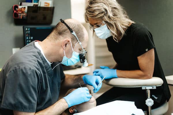 Genesis Dental Salt Lake Dentist and assistant working with patient